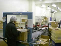 冷凍商品梱包作業場にて梱包作業するスタッフ